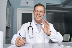 happy-old-male-doctor-talking-during-telehealth-vi-2023-11-27-05-25-41-utc-scaled-1-1920x1280